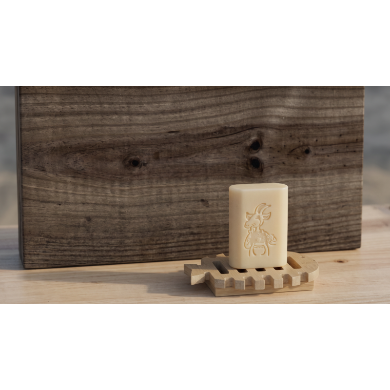 Savon au lait de chevre pose sur un porte-savon en bois en forme de poisson