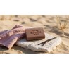 savon artisanal calin brun pose sur pierre calcaire avec un linge rose poudre et de la vanille