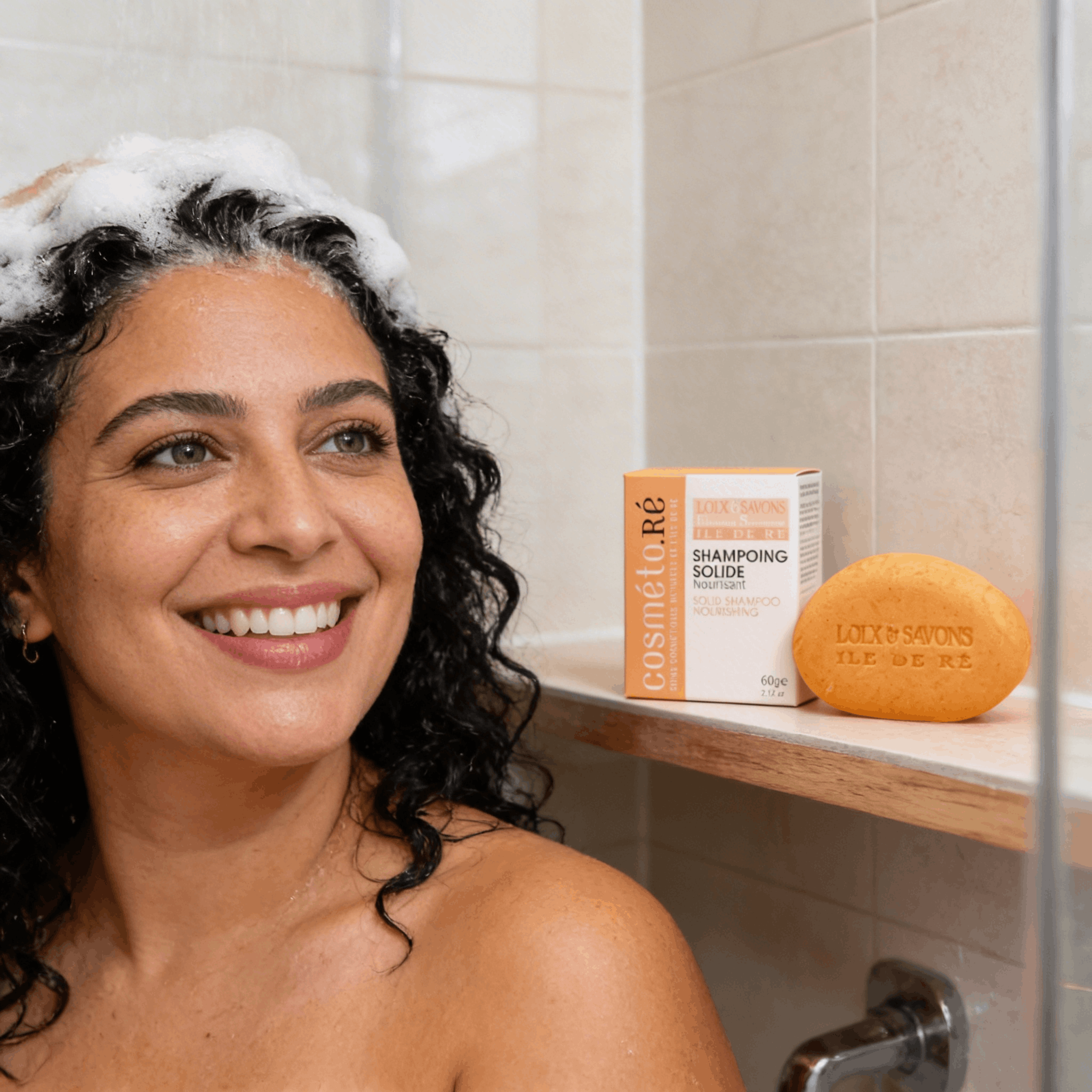 Femme aux cheveux frisés utilisant un shampoing solide nourrissant
