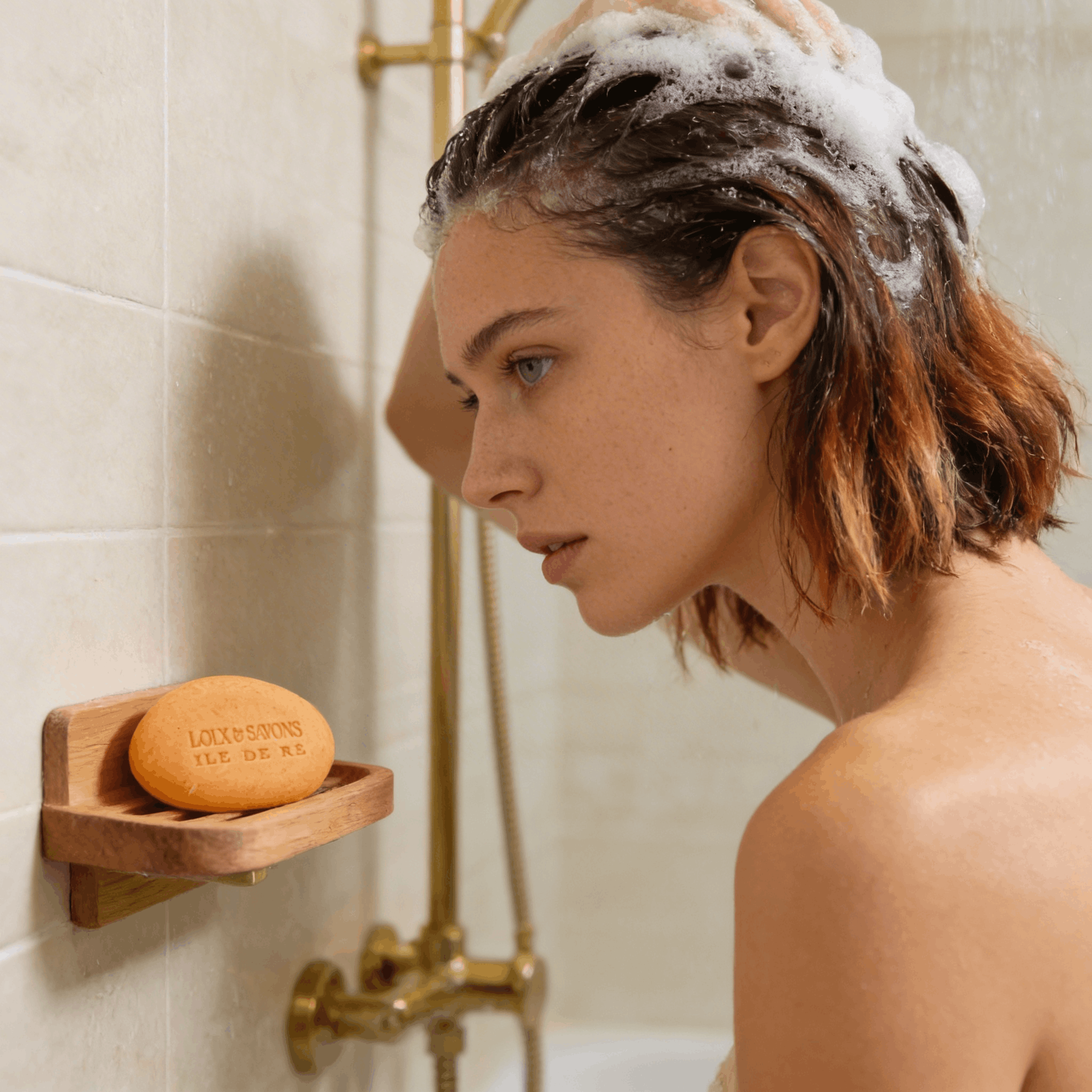 Jeune femme lavant ses cheveux colorés avec un shampoing nourrissant