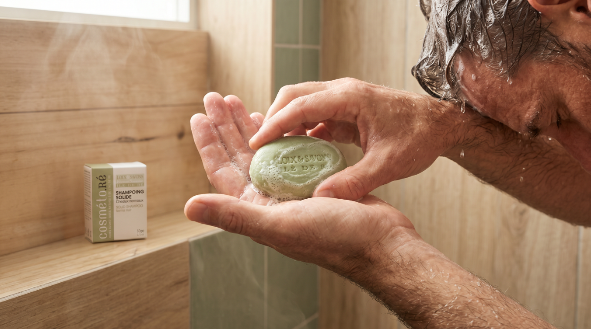 homme fait mousser shampoing solide cheveux normaux sous la douche